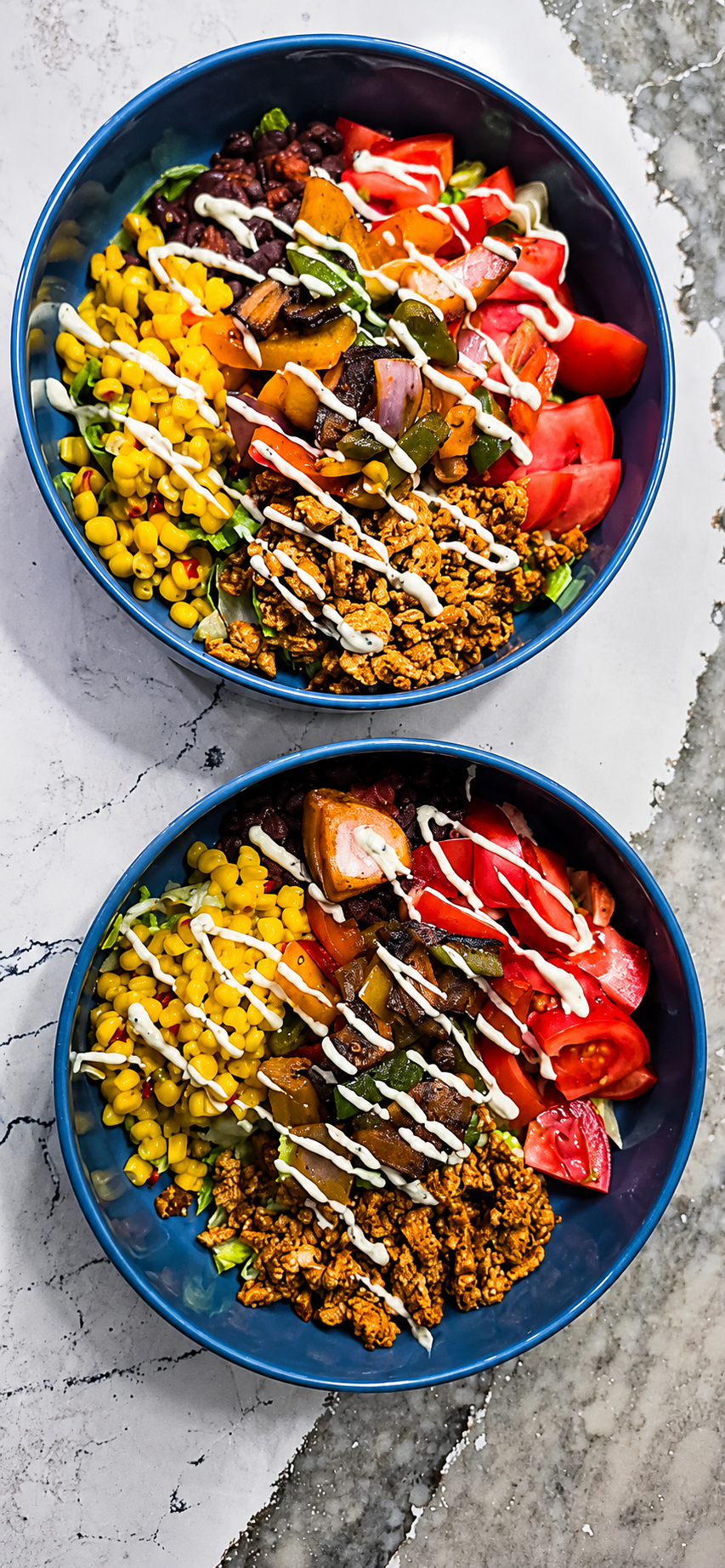 Two colorful chicken bowls with corn, tomatoes, and crema